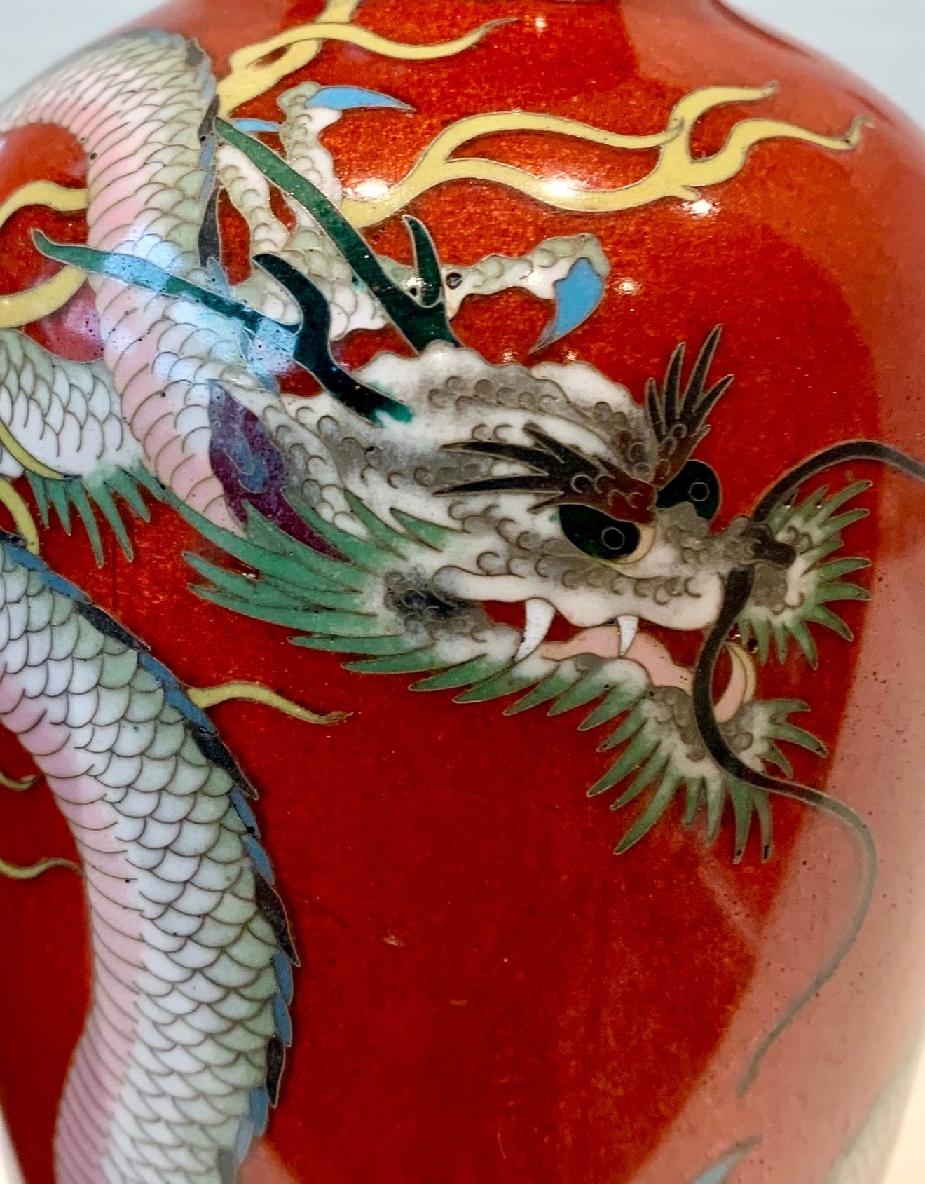 A fine pair of Japanese cloisonné enamel vases decorated with dragons on a rich red ground, Meiji period