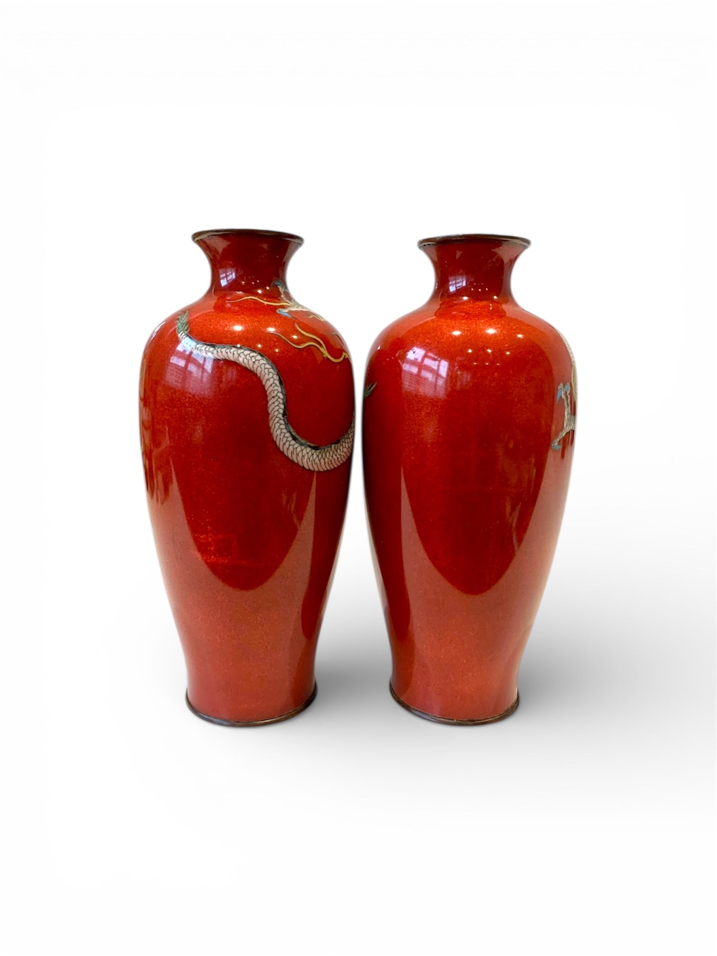 A fine pair of Japanese cloisonné enamel vases decorated with dragons on a rich red ground, Meiji period