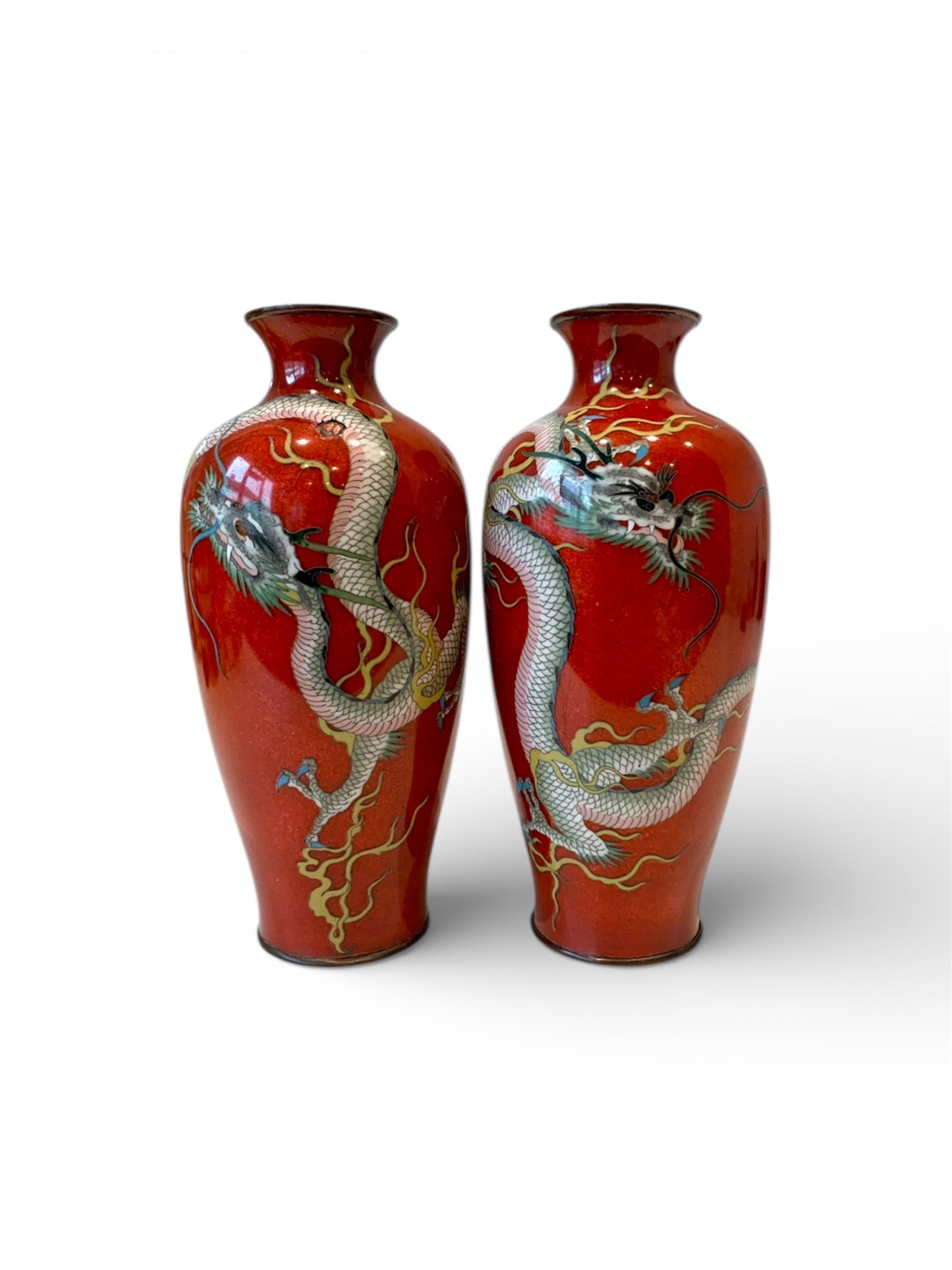 A fine pair of Japanese cloisonné enamel vases decorated with dragons on a rich red ground, Meiji period